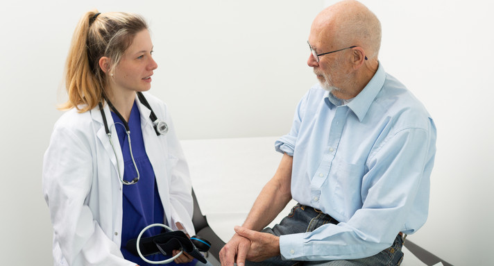 Medizinstudentin spricht mit einem Patienten