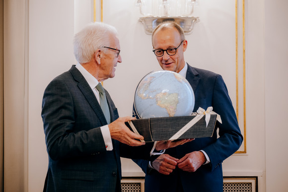 Geschenkübergabe: Ministerpräsident Winfried Kretschmann (links) überreicht Bundeskanzler Friedrich Merz (rechts) einen Leuchtglobus