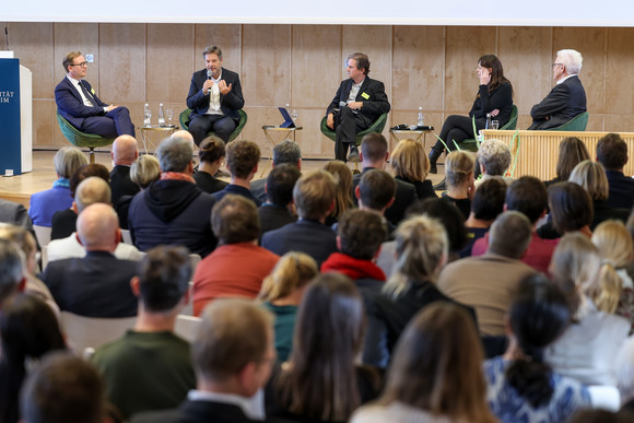 Zusammenhalt in der Transformation Tagung „Gemeinsam handeln“ Podiumsdiskussion mit Prof. Dr. Markus Gabriel (links), The New Institute, Dr. Robert Habeck (Zweiter von links), Vizekanzler und Bundesminister für Wirtschaft und Klimaschutz, Moderator Peter Unfried (Mitte), Prof. Dr. Hedwig Richter (Zweite von rechts), Universität der Bundeswehr München, und Ministerpräsident Winfried Kretschmann (rechts)