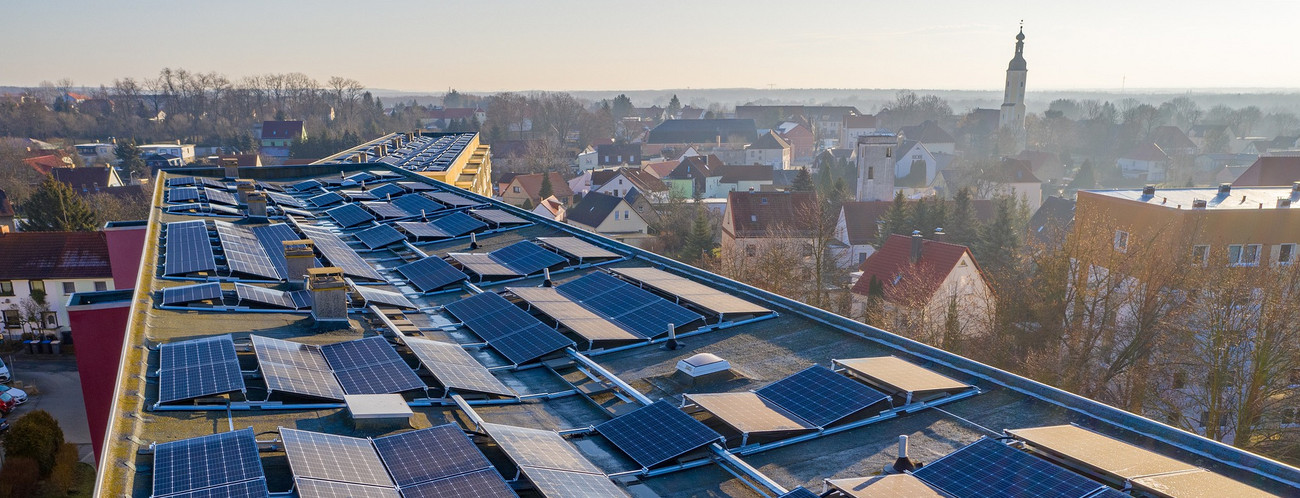 Blick auf ein Gebäudedach mit Solaranlage