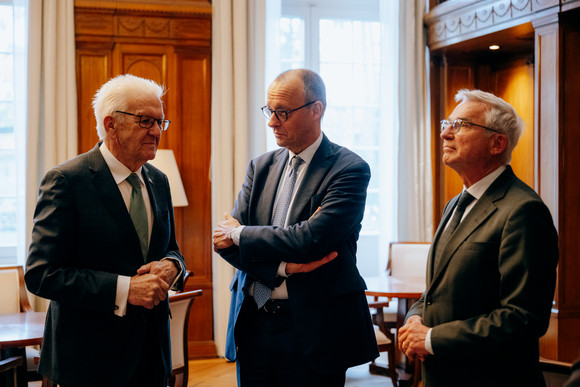 von links nach rechts: Ministerpräsident Winfried Kretschmann, Bundeskanzler Friedrich Merz und Innenminister Thomas Strobl in der Bibliothek