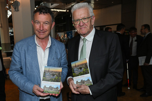 Europa Erstes digitales deutsch-französisches Bürgerportal eröffnet Ministerpräsident Winfried Kretschmann (rechts) und der Präsident der Région Grand Est, Franck Leroy (links), jeweils mit einem Buch in der Hand.