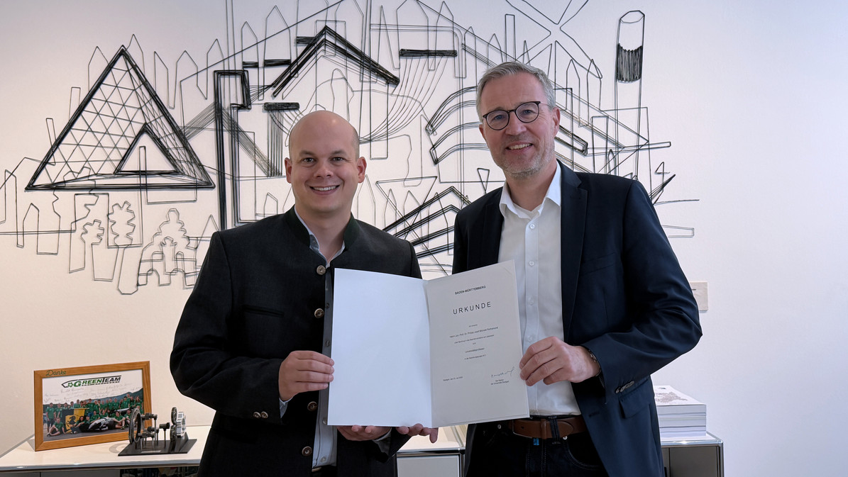 Prof. Peter Middendorf, Rektor der Universität Stuttgart (rechts), überreichte Philipp Rothemund seine Ernennungsurkunde zum W3-Professor für Soft Robotics for Autonomous and Biomedical Systems