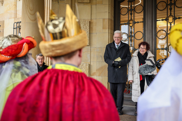 Ministerpräsident Winfried Kretschmann und seine Ehefrau Gerlinde (rechts) begrüßen die Sternsingerinnen und Sternsingern am Eingang der Villa Reitzenstein. 