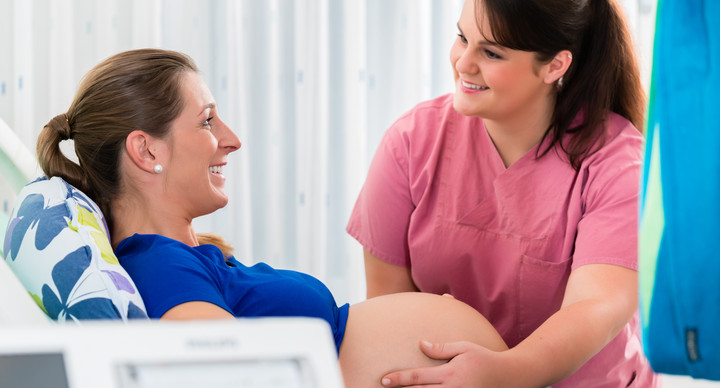 Pregnant woman in delivery room with CTG monitoring