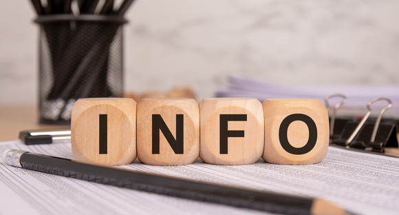 Online-Wegweiser Studieninformationen für Geflüchtete Wooden cubes with "INFO" text on financial documents, symbolizing business information and data.