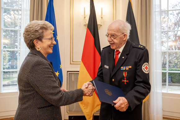 Staatsrätin Barbara Bosch (links) überreicht Walter Adler (rechts) das Bundesverdienstkreuz.