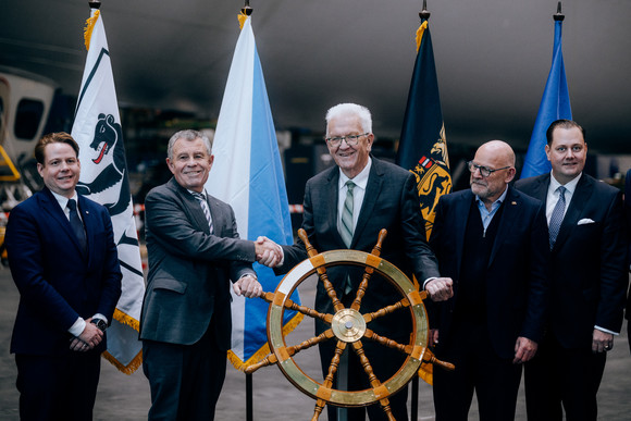 Symbolische Steuerradübergabe im Zeppelin-Hangar Friedrichshafen: Ministerpräsident Winfried Kretschmann (Mitte) und Ernst Stocker (Zweiter von links), Regierungsrat des Kantons Zürich.