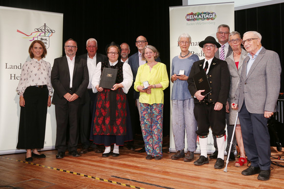 Ministerin Petra Olschowski (ganz links)  mit den Trägerinnen und Trägern der Heimatmedaille Baden-Württemberg. 