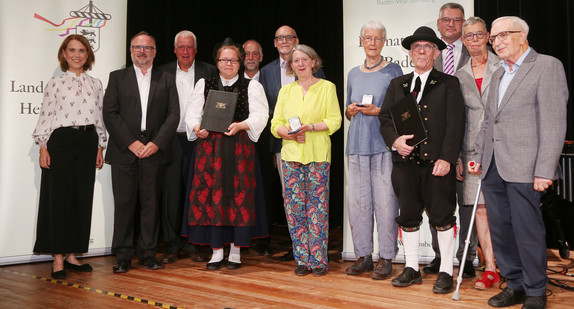 Ministerin Petra Olschowski (ganz links)  mit den Trägerinnen und Trägern der Heimatmedaille Baden-Württemberg. 