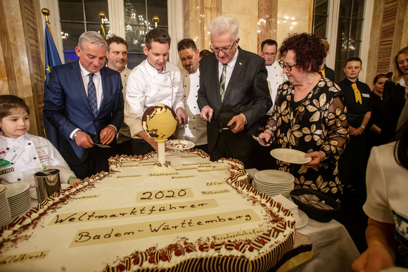 Neujahrsempfang der Landesregierung „Baden-Württemberg: weltweit vernetzt“ Ministerpräsident Winfried Kretschmann (2.v.r.) und Ehefrau Gerlinde (r.) sowie Innenminister Thomas Strobl (l.) beim Anschnitt einer Baden-Württemberg-Torte (Bild: Staatsministerium Baden-Württemberg)
