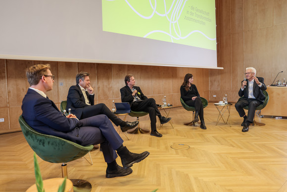 Zusammenhalt in der Transformation Tagung „Gemeinsam handeln“ Podiumsdiskussion mit Prof. Dr. Markus Gabriel (links), The New Institute, Dr. Robert Habeck (Zweiter von links), Vizekanzler und Bundesminister für Wirtschaft und Klimaschutz, Moderator Peter Unfried (Mitte), Prof. Dr. Hedwig Richter (Zweite von rechts), Universität der Bundeswehr München, und Ministerpräsident Winfried Kretschmann (rechts)