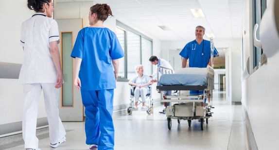 hospital, corridor, nurse, male, bed, gurney, pushing, stretcher, female, senior, patient, doctor, wheelchair, sitting, old, woman, healthcare, worker, elderly, care, help, disabled, disability, clinic, old age, retirement, pensioner, health, illness, caucasian, blue, uniform, treatment, mobility