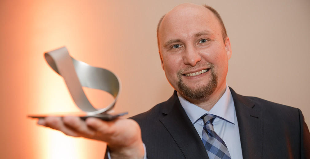 Dr. med. Georg Gdynia mit dem in Form eines Möbiusbandes gestalteten Landesforschungspreis, Foto: MWK/Jan Potente