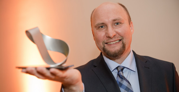 Forschung Verleihung des Landesforschungspreises und des Preises für mutige Wissenschaft 2016 Dr. med. Georg Gdynia mit dem in Form eines Möbiusbandes gestalteten Landesforschungspreis, Foto: MWK/Jan Potente