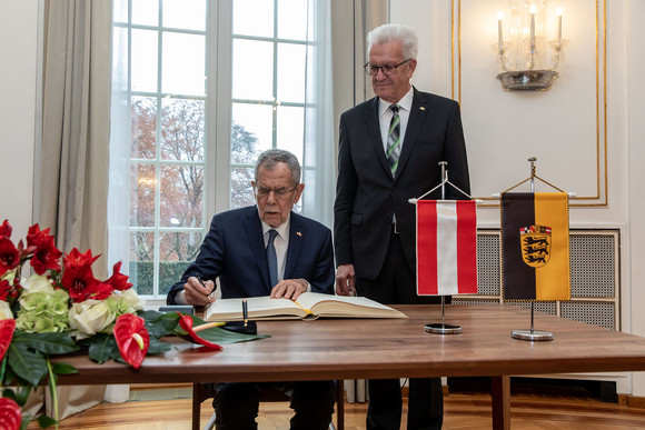 Besuch Österreichischer Bundespräsident besucht Baden-Württemberg Der österreichische Bundespräsident Dr. Alexander Van der Bellen (l.) beim Eintrag in das Gästebuch der Landesregierung, daneben Ministerpräsident Winfried Kretschmann (r.) (Bild: Staatsministerium Baden-Württemberg)