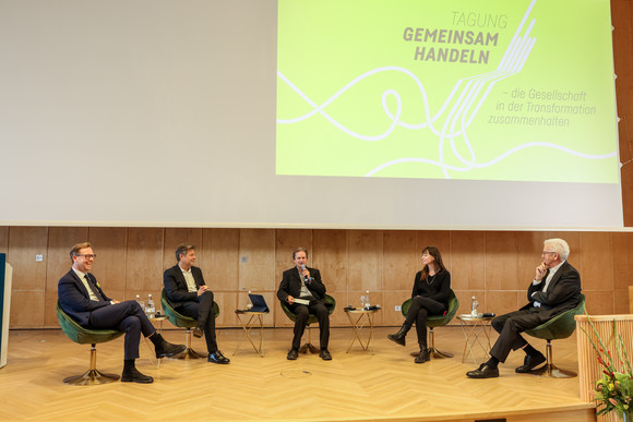 Zusammenhalt in der Transformation Tagung „Gemeinsam handeln“ Podiumsdiskussion mit Prof. Dr. Markus Gabriel (links), The New Institute, Dr. Robert Habeck (Zweiter von links), Vizekanzler und Bundesminister für Wirtschaft und Klimaschutz, Moderator Peter Unfried (Mitte), Prof. Dr. Hedwig Richter (Zweite von rechts), Universität der Bundeswehr München, und Ministerpräsident Winfried Kretschmann (rechts)