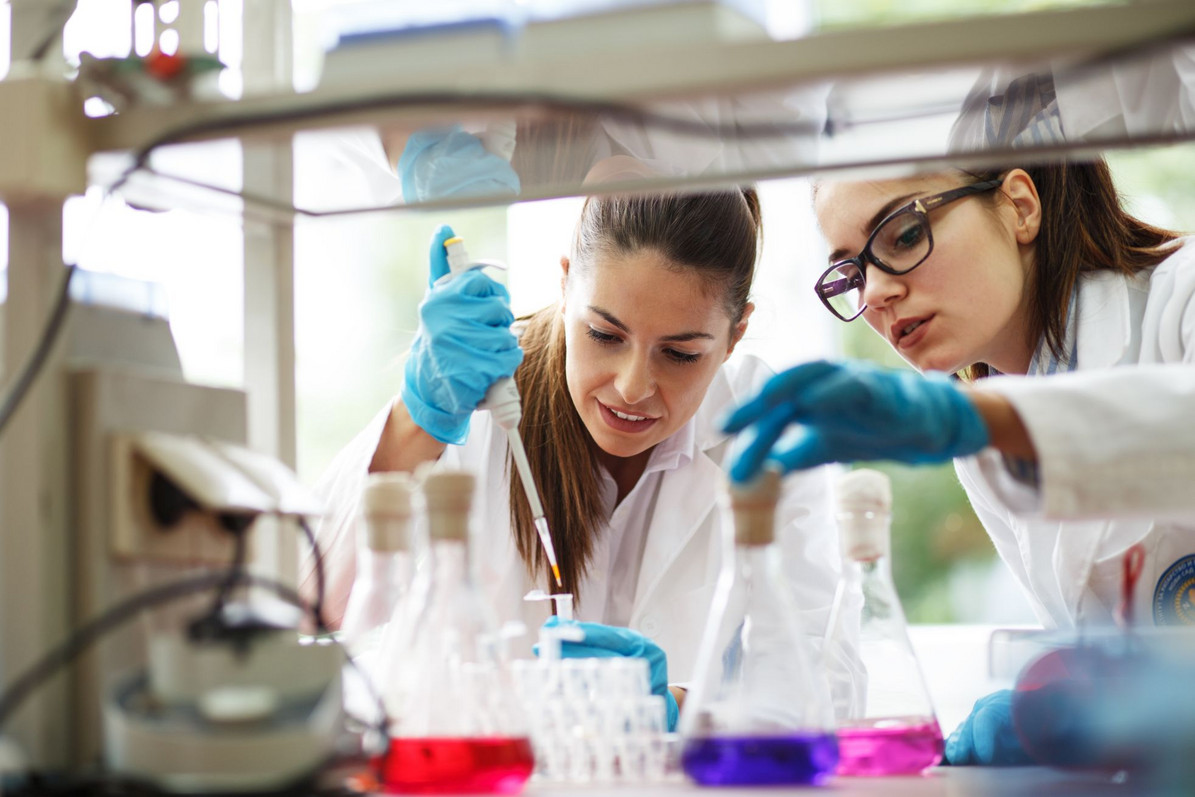 Zwei junge Wissenschaftlerinnen machen Experimente im Labor.