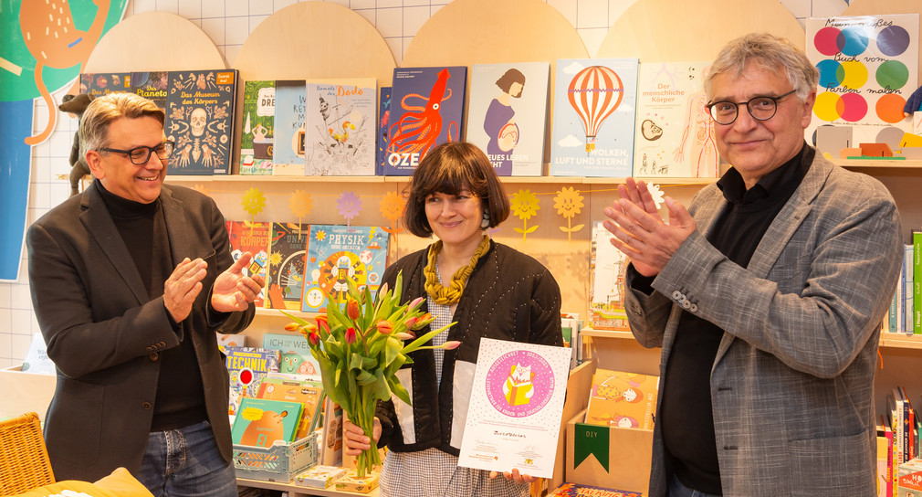 Kunststaatssekretär Arne Braun (rechts) bei der Verleihung des Gütesiegels in der Stuttgarter Kinderbuchhandlung BUCHSTÄBCHEN