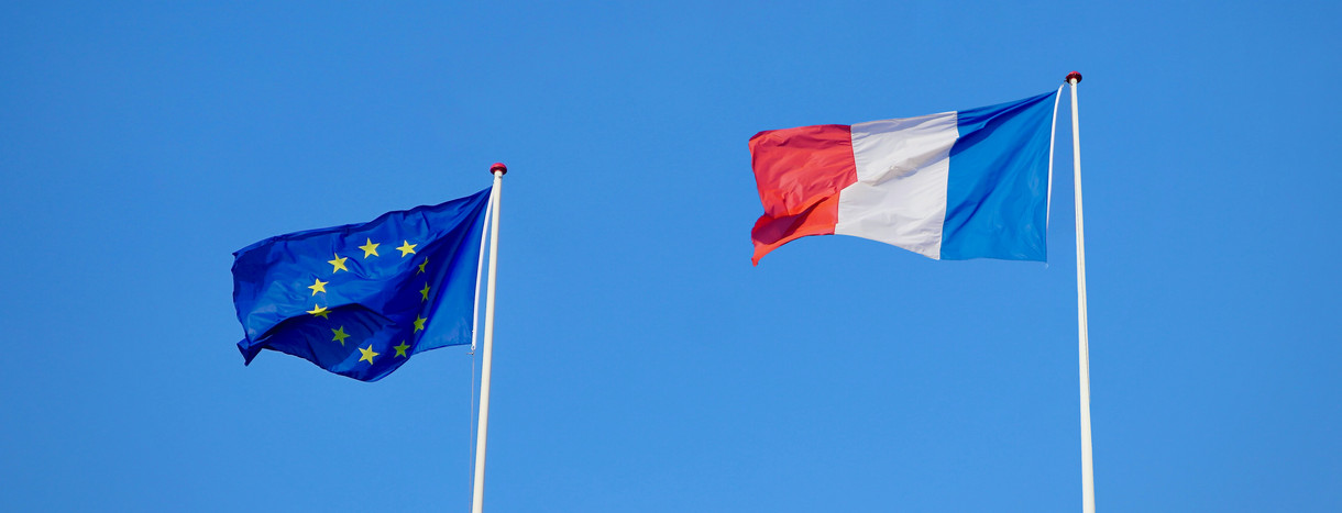 Zwei Flaggen nebeneinader: links EU, rechts Frankreich