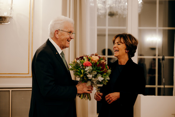 Ministerpräsident Winfried Kretschmann (links) übergibt Dr. Nicola Leibinger-Kammüller (rechts) einen Blumenstrauß.