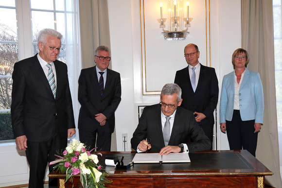 Besoldung Mehr Geld für Beamte Staatssekretär Martin Jäger (sitzend) unterzeichnet die Vereinbarung; stehend v.l.n.r.: Ministerpräsident Winfried Kretschmann, Volker Stich, Vorsitzender des Beamtenbundes Baden-Württemberg, , Matthias Grewe, Vorsitzender des Vereins der Richter und Staatsanwälte Baden-Württemberg e.V., und Finanzministerin Edith Sitzmann