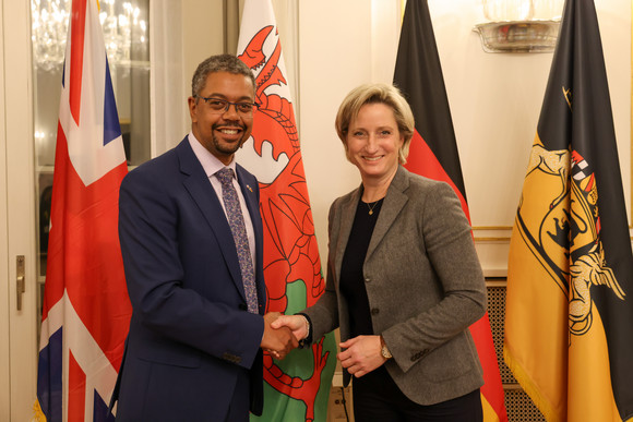 Europa Wales und Baden-Württemberg bauen Zusammenarbeit aus Wirtschaftsministerin Dr. Nicole Hoffmeister-Kraut (rechts) und der walisische Wirtschaftsminister Vaughan Gething (links) stehen vor Fahnen und geben sich die Hand.