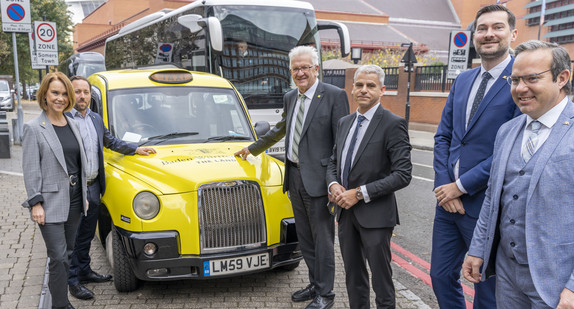 Petra Olschowski vor einem Londoner Taxi im Design der neuen „THE LÄND“-Kampagne 