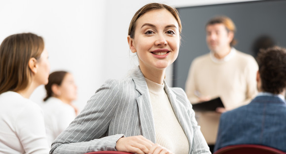 Reform Lehrerbildung Young smiling female student sitting in college class