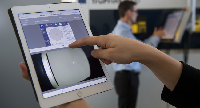 Eine Mitarbeiterin demonstriert im 3D-Druck-Applikationszentrum des Maschinenbauers Trumpf in Ditzingen die Bedienung einer 3D-Druck-Maschine per Tablet. (Foto: © dpa)']