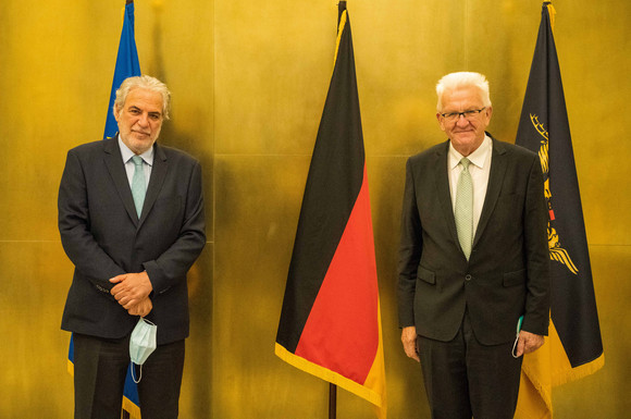 Gespräch Kretschmann trifft EU-Sonderbeauftragten Stylianides Ministerpräsident Winfried Kretschmann (r.) und Christos Stylianides (l.) stehen vor Fahnen.